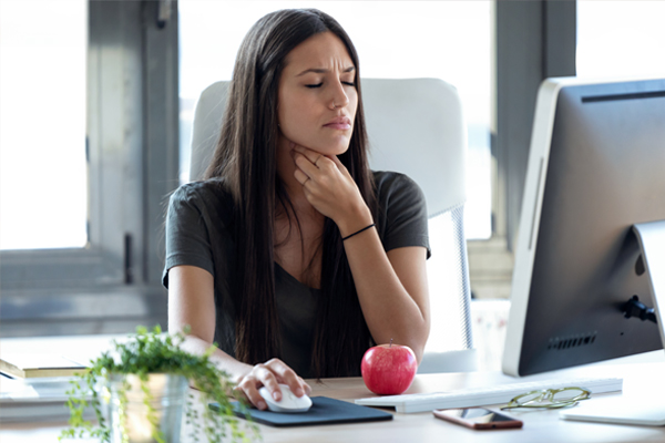 Woman with sore throat at work